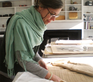 Woman in a shawl inspecting fabric