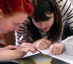 Two students inspecting a painting