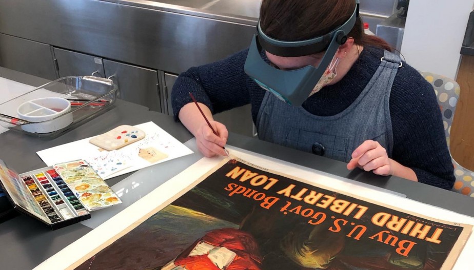 Kathryn Kenney examining a poster print in the lab