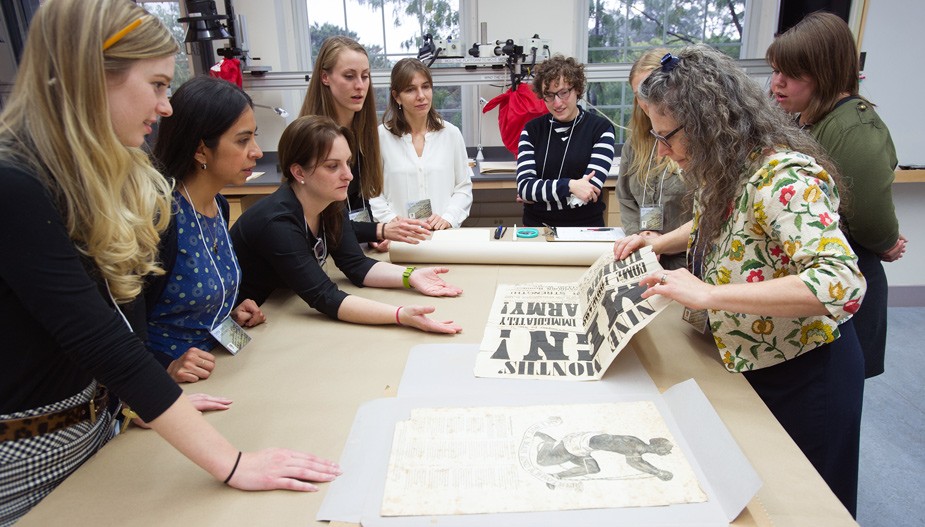 Students and professor examine print piece